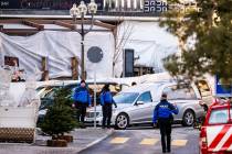 A hearse car drives as police officers inspect the area where a fire broke out at the Le Conste ...
