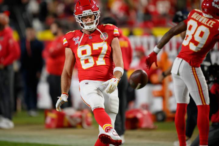 Kansas City Chiefs tight end Travis Kelce kicks the ball back to an assistant during warmups be ...