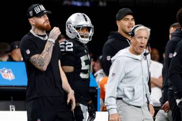 Raiders defensive end Maxx Crosby, left and linebacker Elandon Roberts (52) and head coach Pete ...