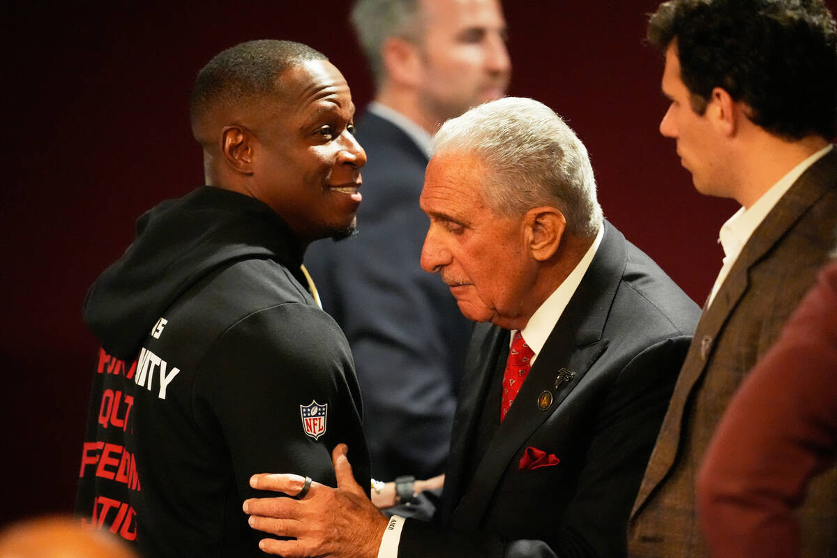 Atlanta Falcons owner Arthur Blank, right, hugs head coach Raheem Morris after an NFL football ...