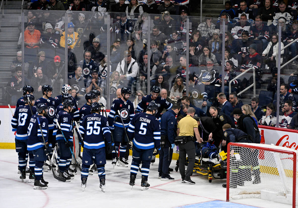 Winnipeg Jets' Haydn Fleury is helped off the ice after being injured against the Vegas Go ...