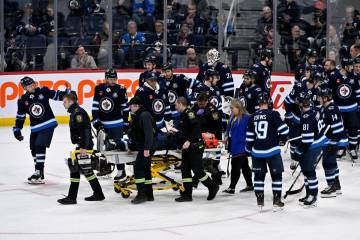 Winnipeg Jets' Haydn Fleury is helped off the ice after being injured against the Vegas Go ...