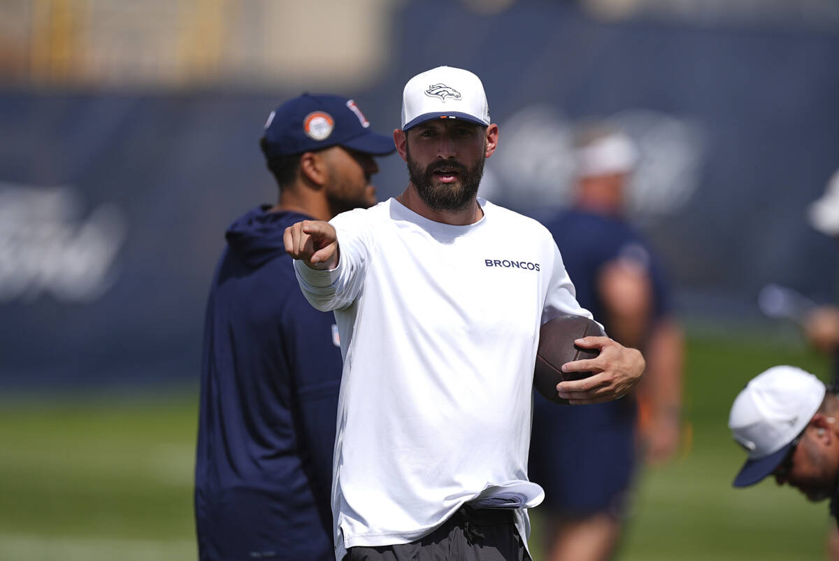 Denver Broncos quarterbacks coach Davis Webb directs players at an NFL football training practi ...