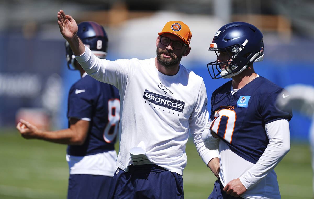 Denver Broncos quarterbacks coach Davis Webb, left, directs quarterback Bo Nix during Back Toge ...