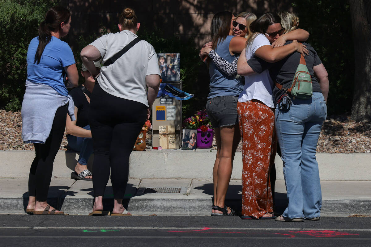 Family and friends comfort each other on West Tropical Parkway near North Emerald Eagle Street ...
