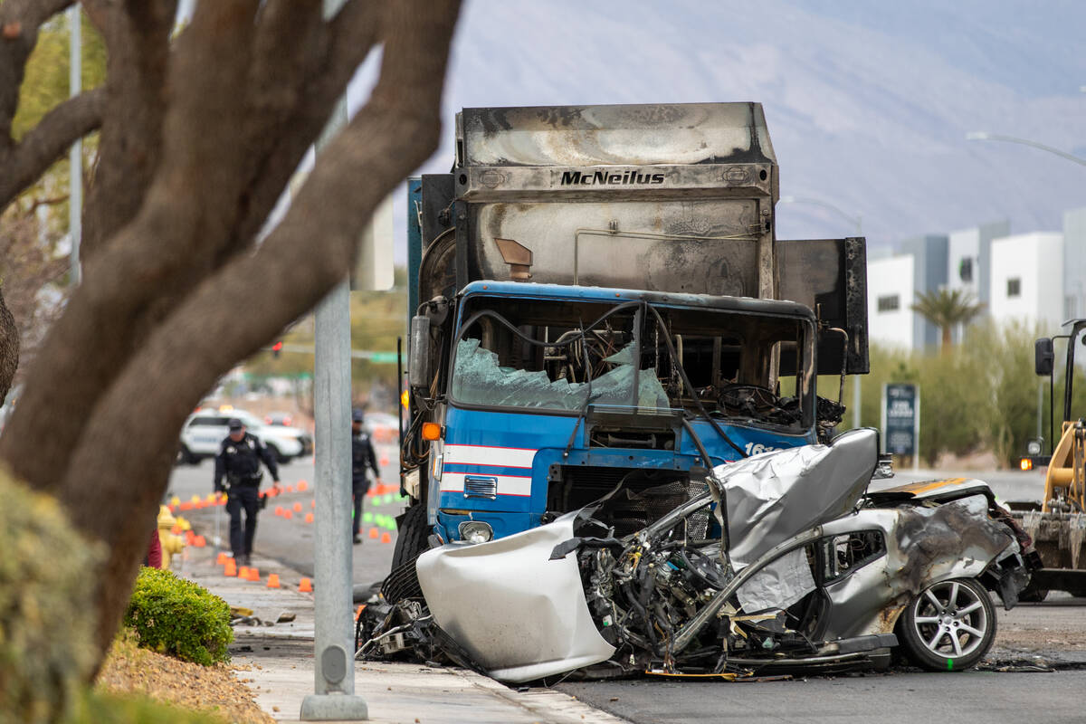 A burnt trash truck and mangled silver vehicle lie on a stretch of Cheyenne Ave on Wednesday af ...