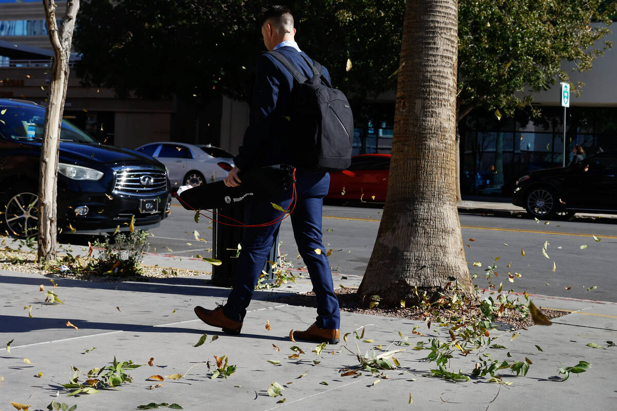 The wind blows leaves as a pedestrian walks along Third Street in Downtown Las Vegas on Thursda ...