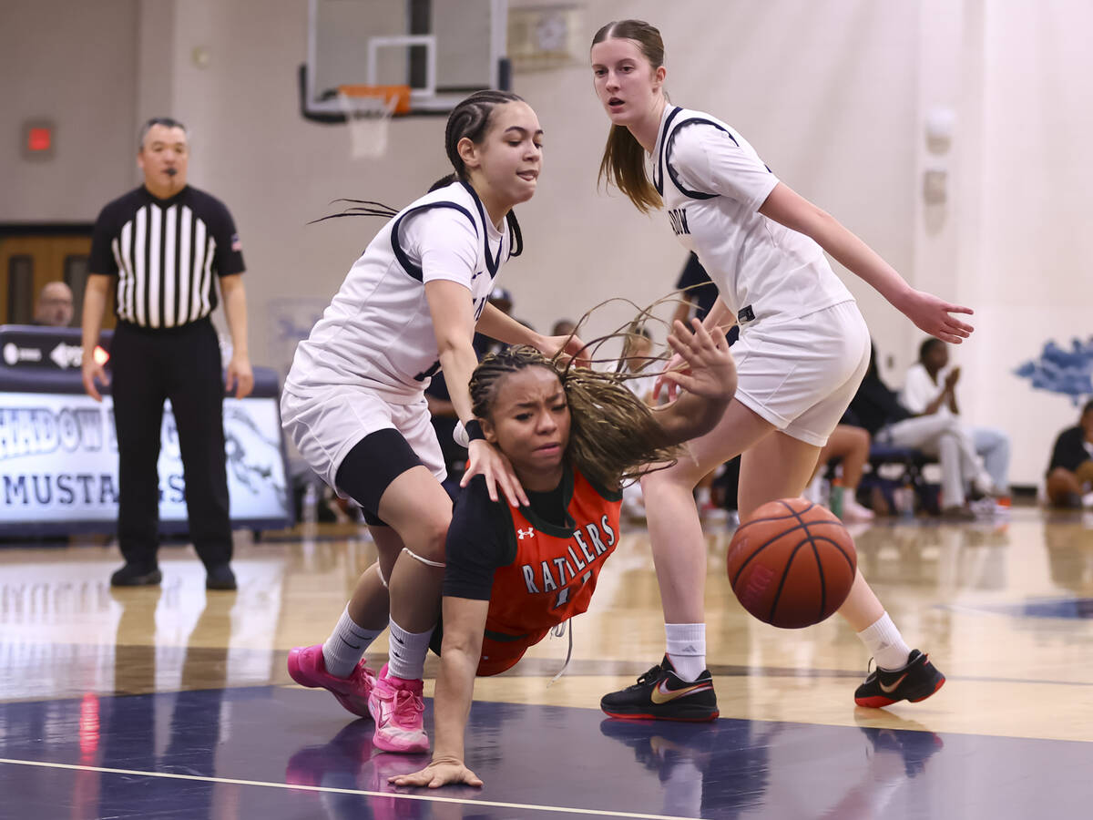 Mojave’s Armonney Wright (11) gets tripped up by Shadow Ridge guard Chanel Gafeney, left ...