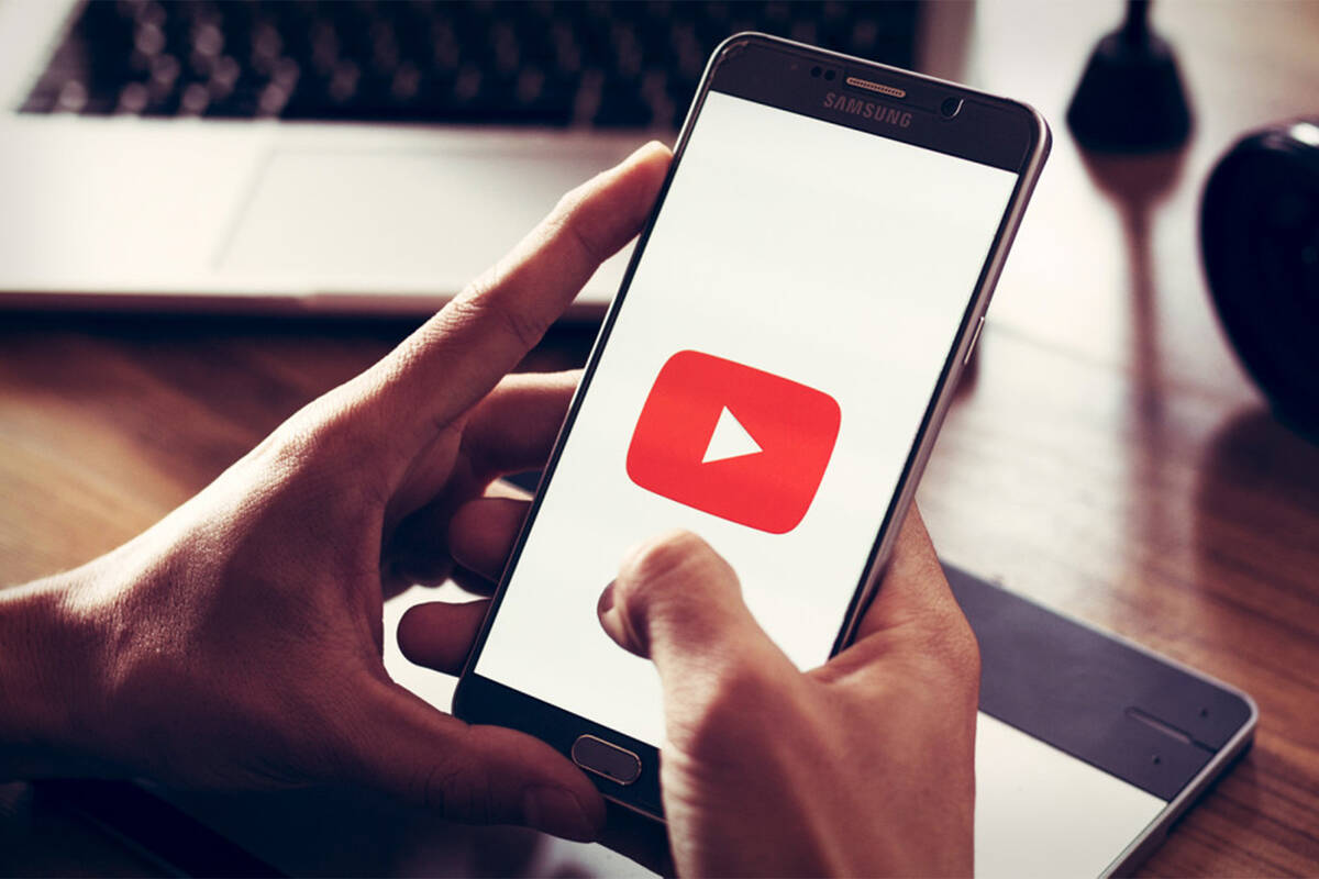 A person opening the YouTube app on their smartphone. (AMG-TheStreet)