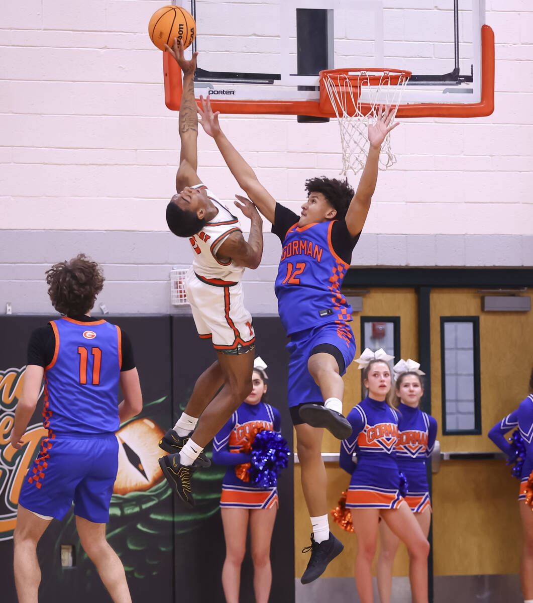 Mojave guard Phillip Gordon (5) tries to get the ball around Bishop Gorman forward Braylen Will ...