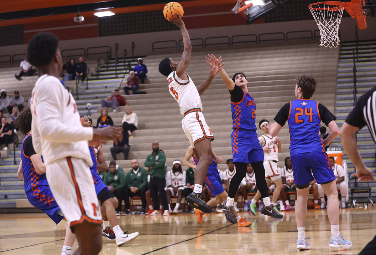 Mojave guard Phillip Gordon (5) lays up the ball against Bishop Gorman guard Dino Roberts (2) d ...