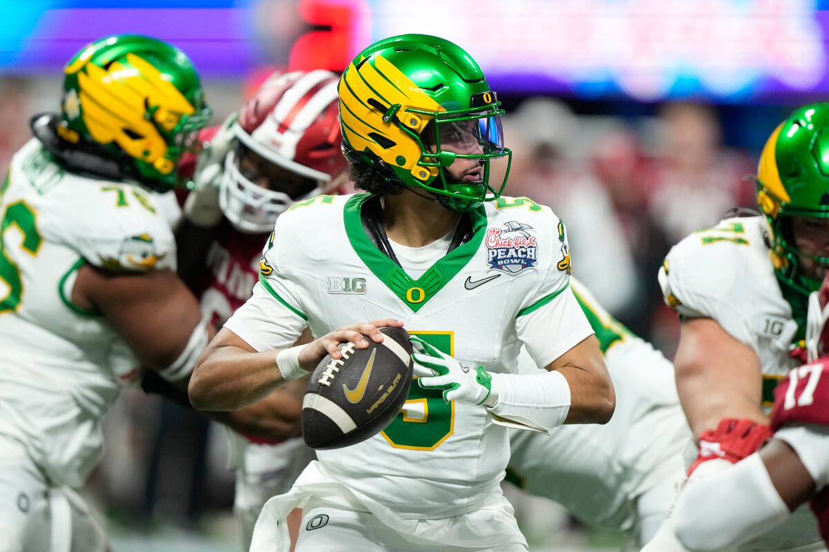 Oregon quarterback Dante Moore (5) drops back to pass against Indiana during the first half of ...