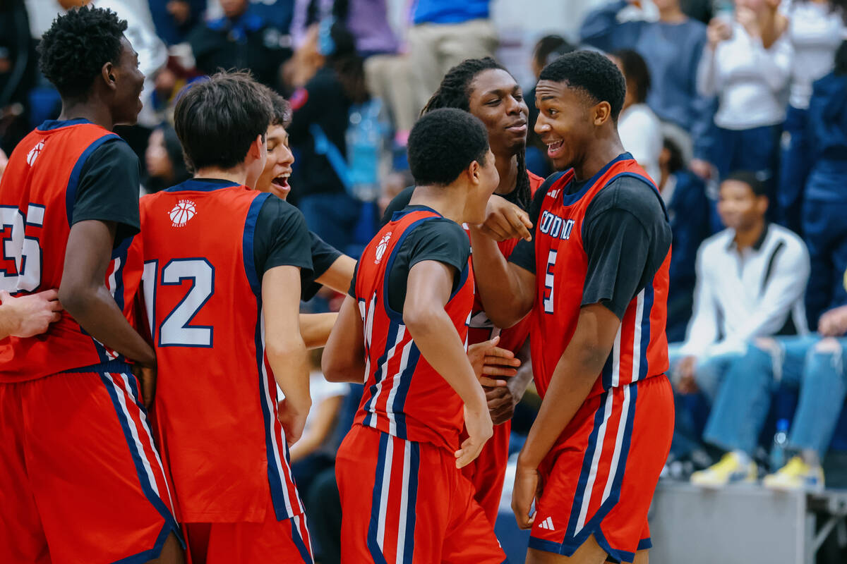 Coronado players surround teammate DeVaughn Dorrough (5), right, after the Cougars narrowly bea ...