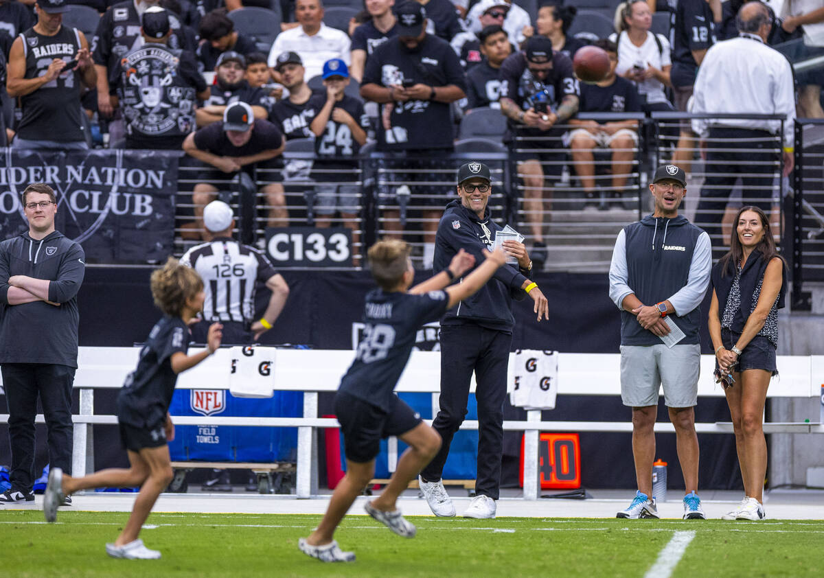 Raiders part owner Tom Brady throws a pass to the children of general manager John Spytek who l ...