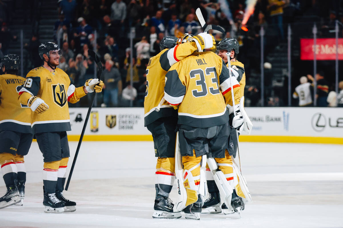 Golden Knights goaltender Adin Hill (33) embraces his teammates after an overtime win during an ...