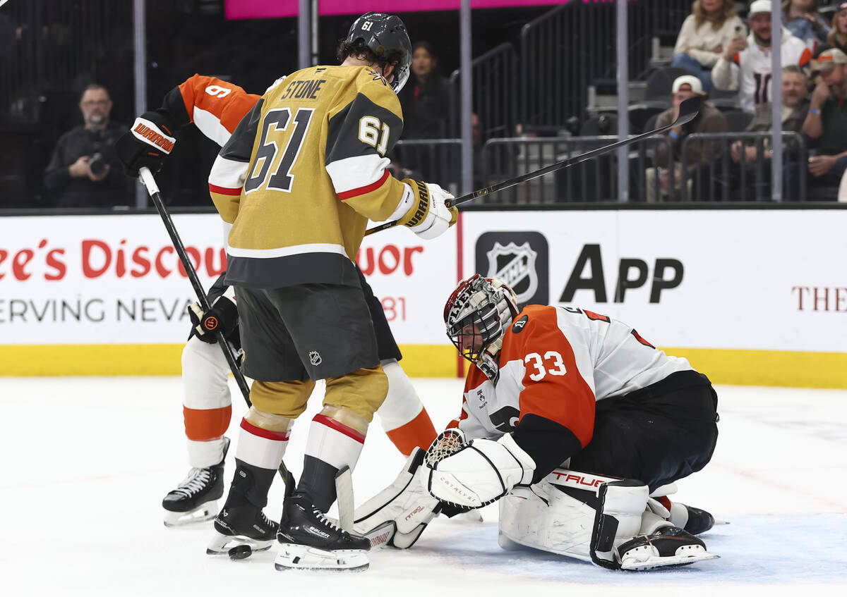 Philadelphia Flyers goaltender Samuel Ersson (33) knocks the puck from between the skates of Go ...