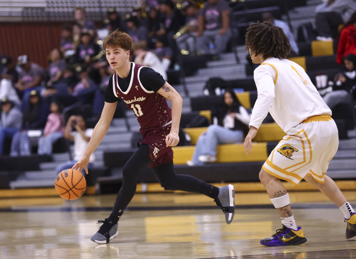 Faith Lutheran guard Jackson Klein (11) brings the ball up court against Clark guard Amir Wrigh ...