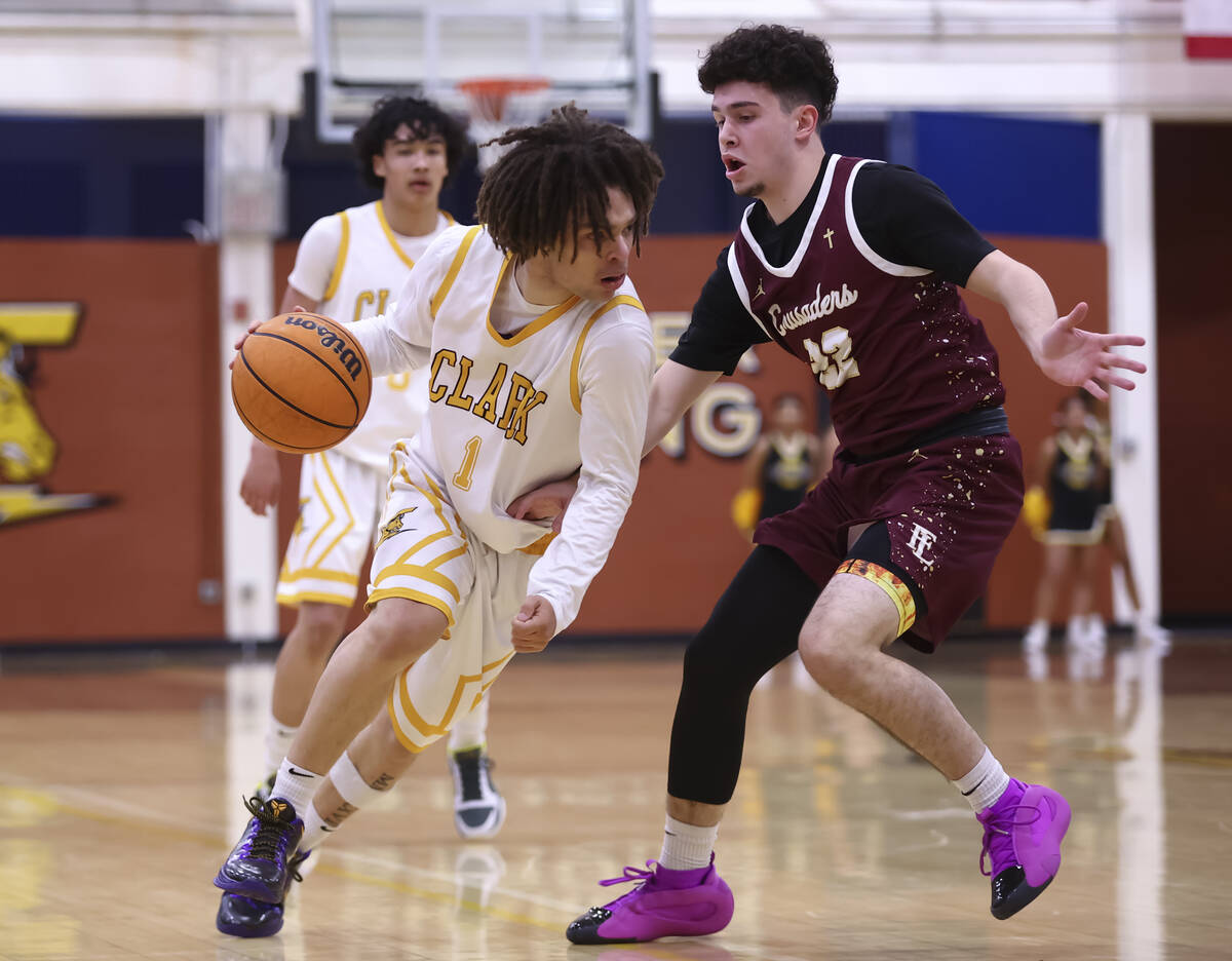 Clark's Amir Wright (1) drives to the basket against Faith Lutheran's Bentley Swinn ( ...