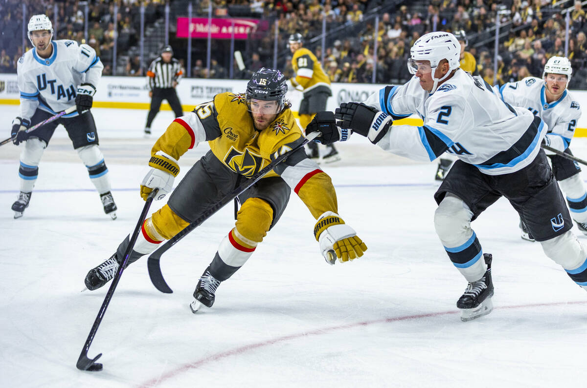 Golden Knights defenseman Noah Hanifin (15) gets a stick from Utah Mammoth defenseman Olli M&#x ...
