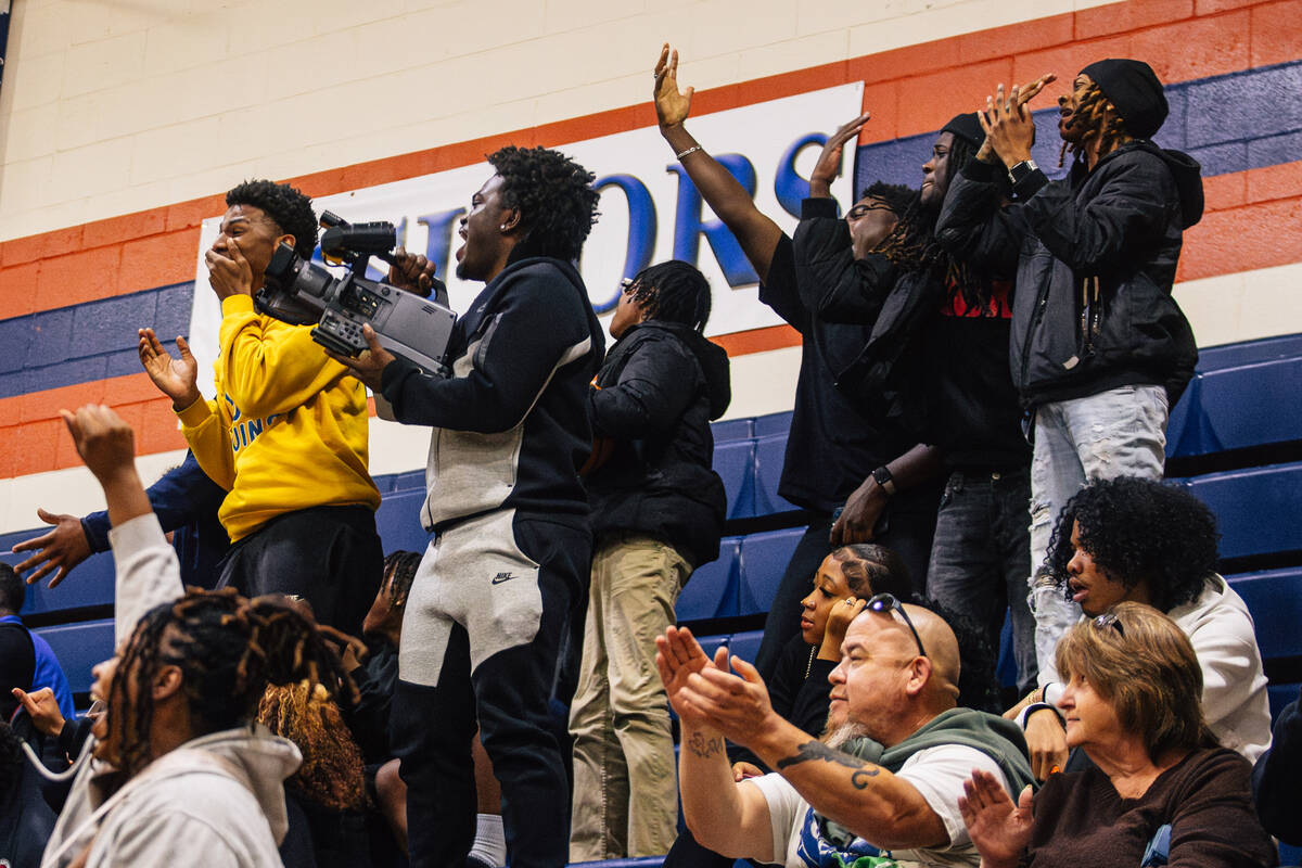 Democracy Prep fans cheer and record the game on a video camera during a girls basketball game ...
