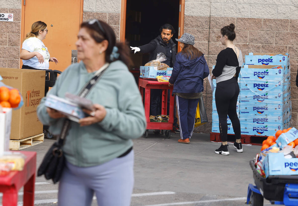 Clients line up to pick up food pantry items at Catholic Charities of Southern Nevada on Wednes ...