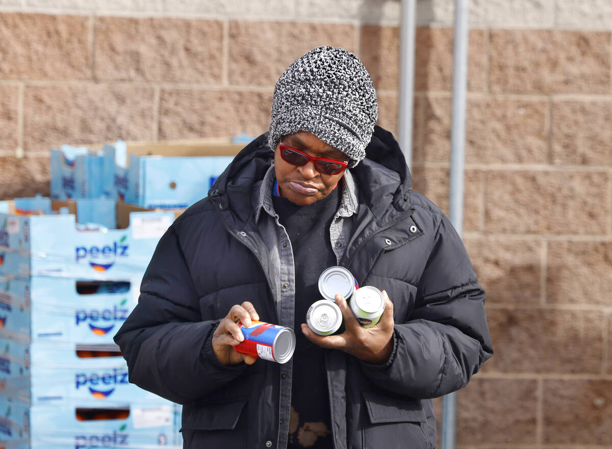 Rigina Conway checks out canned foods as she picks up food pantry items at Catholic Charities o ...