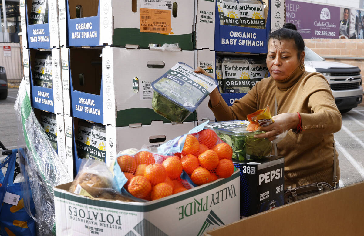 Maria Catiyo picks up food pantry items at Catholic Charities of Southern Nevada on Wednesday, ...