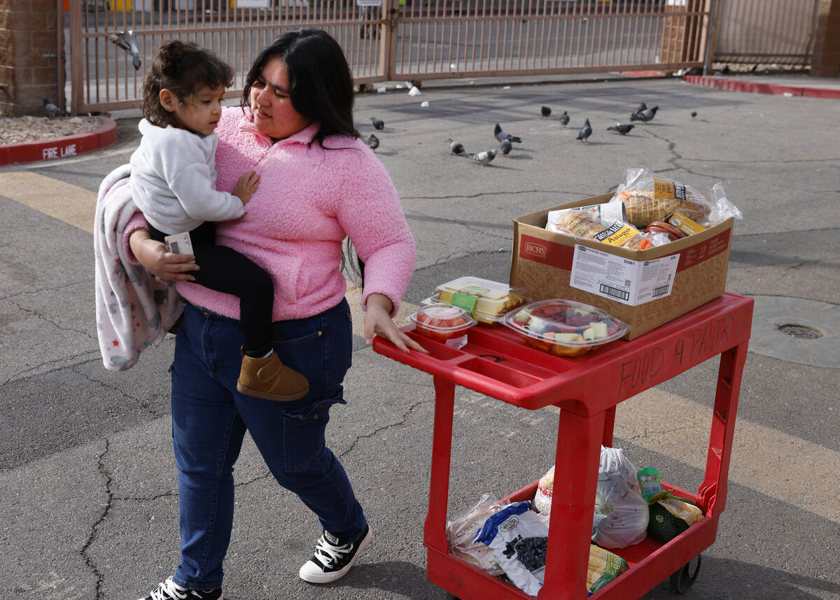 Johana Santos and her daughter Ariany, 2, pick up food pantry items at Catholic Charities of So ...