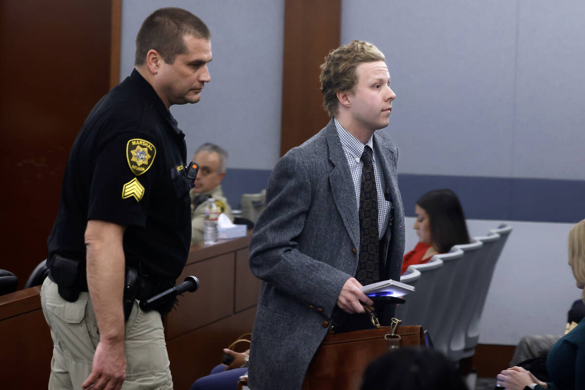The Las Vegas Review-Journal reporter Noble Brigham is escorted out of a courtroom after Distri ...