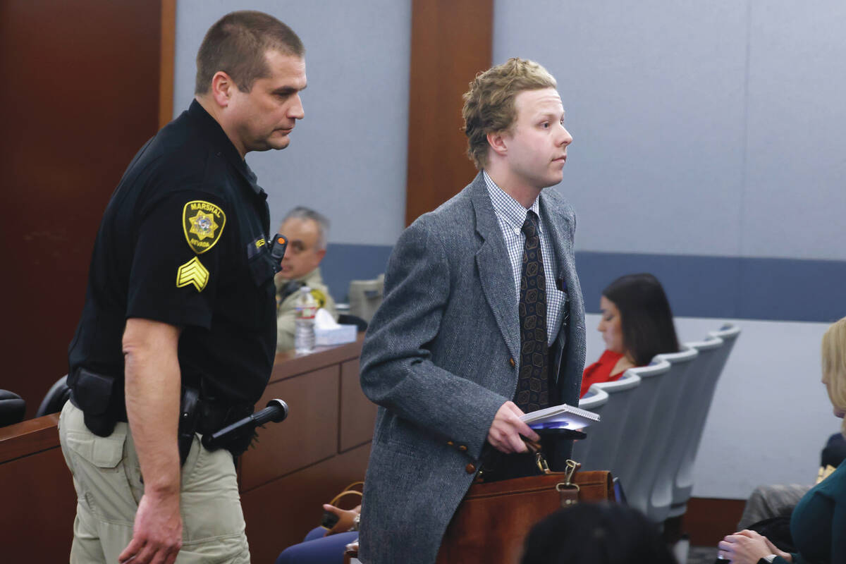 The Las Vegas Review-Journal reporter Noble Brigham is escorted out of a courtroom after Distri ...