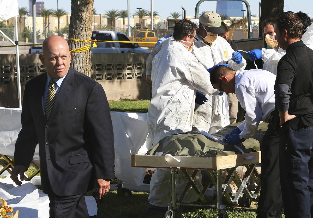 Clark County Coroner Michael Murphy, left, oversees the exhumation of a 1997 homicide victim at ...