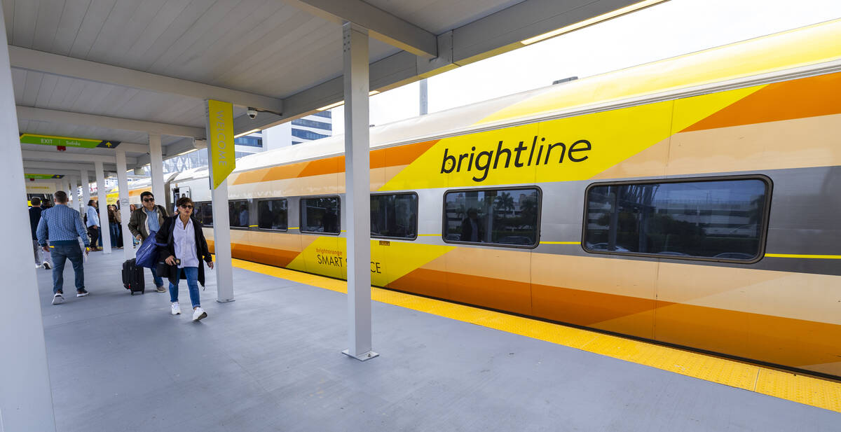 Passengers move about a train at the Brightline Aventura Station on Saturday, Jan. 17, 2026, in ...