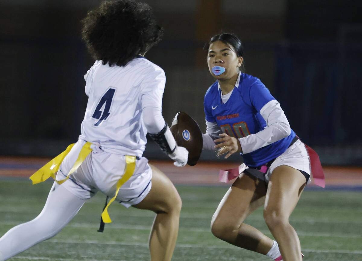 Bishop Gorman's quarterback Zehani English (00) evades a flag pull by Shadow Ridge's ...