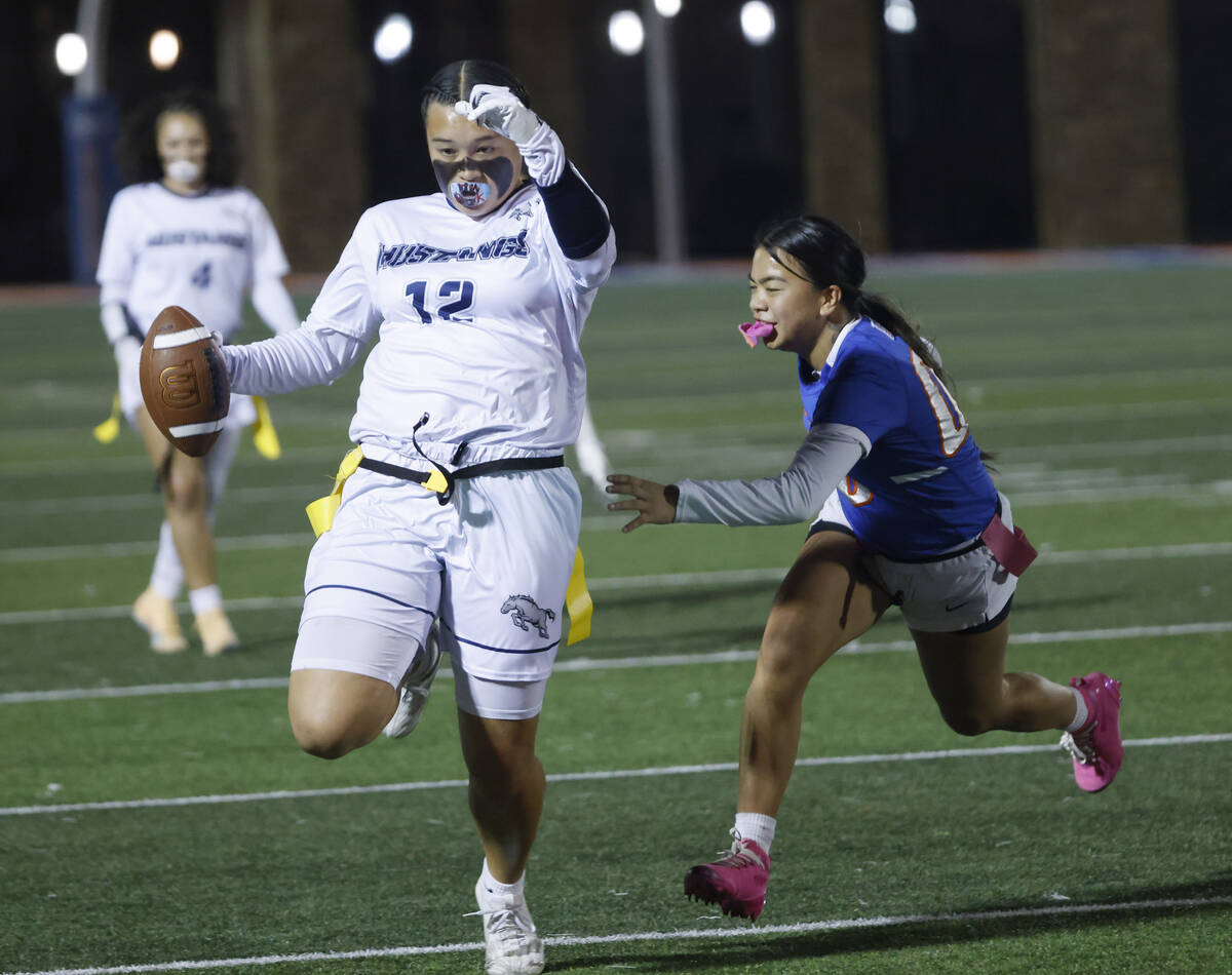 Shadow Ridge's Jaylani Palmer (12) evades a flag pull on a run by Bishop Gorman's def ...