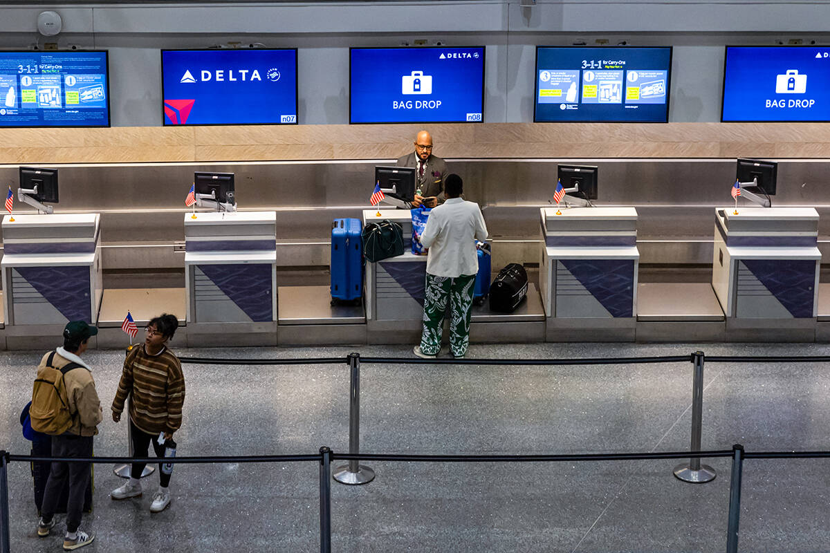 A traveler is assisted at the Delta Air Lines counter at Harry Reid International Airport on Tu ...