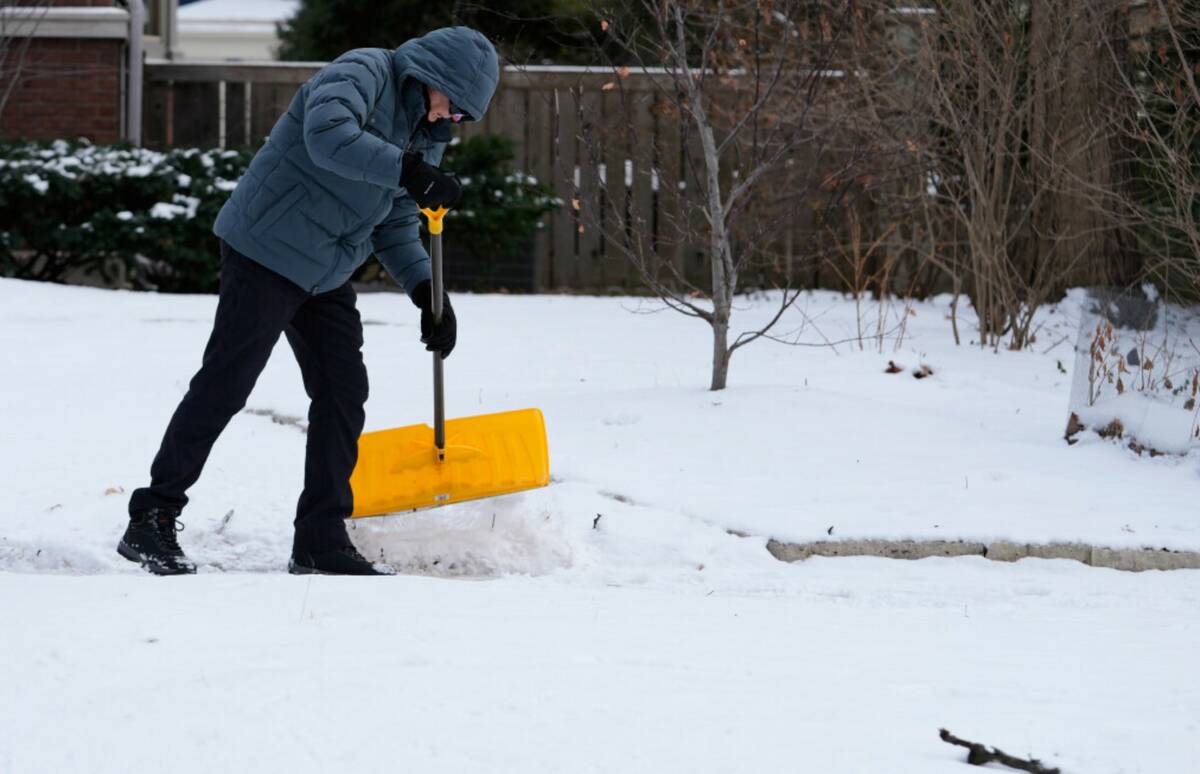 A person cleans snow during a cold weather in Evanston, Ill., Thursday, Jan. 22, 2026. (AP Phot ...
