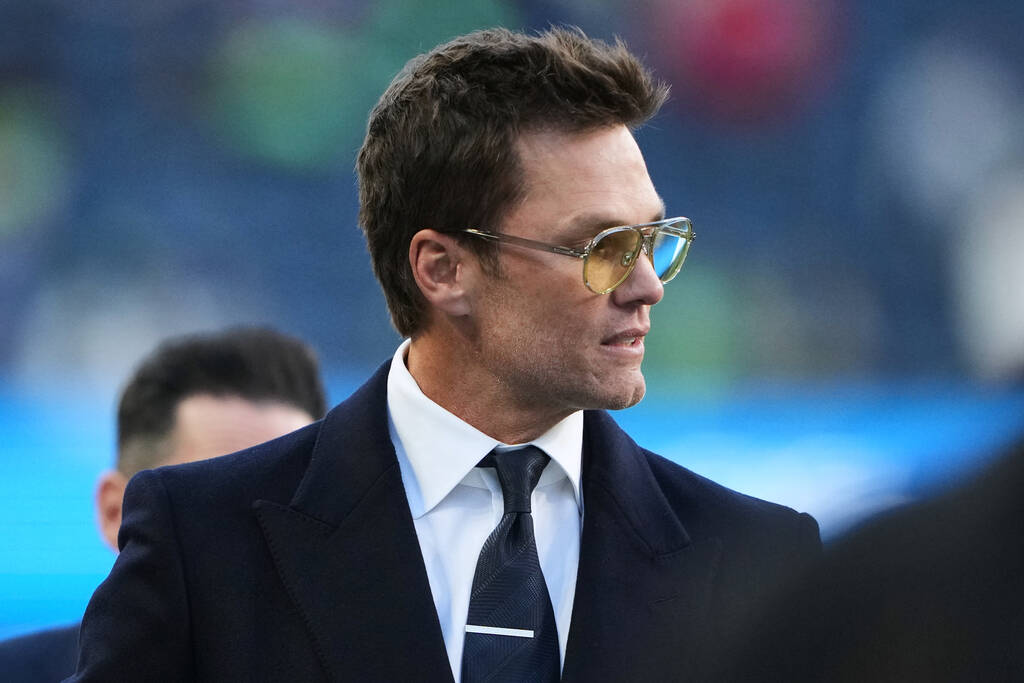 Raiders minority owner Tom Brady walks on the field before an NFL football divisional playoff g ...