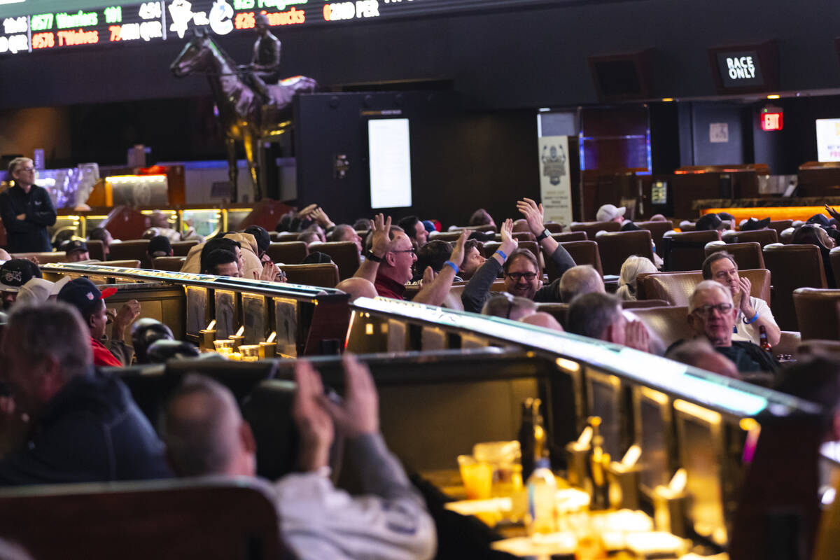 Bettors react to a touchdown by the Rams while watching the NFC championship football game agai ...