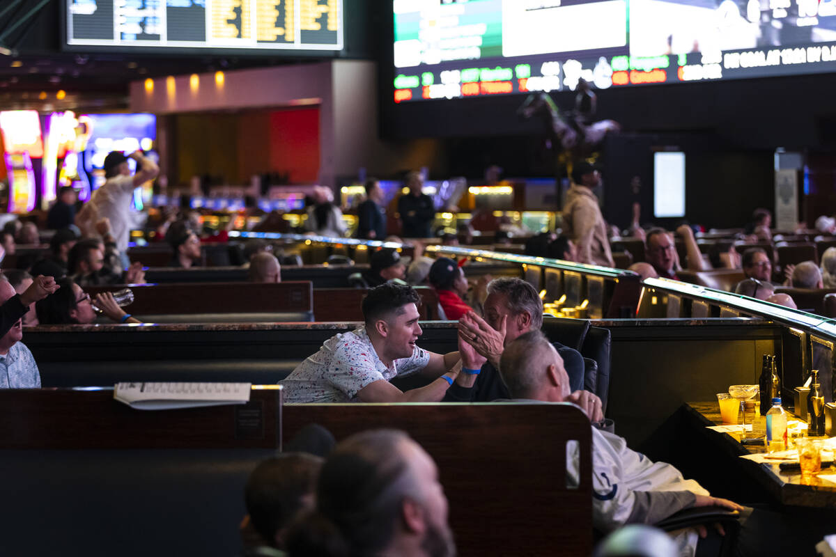 Bettors react to a touchdown by the Rams while watching the NFC championship football game agai ...