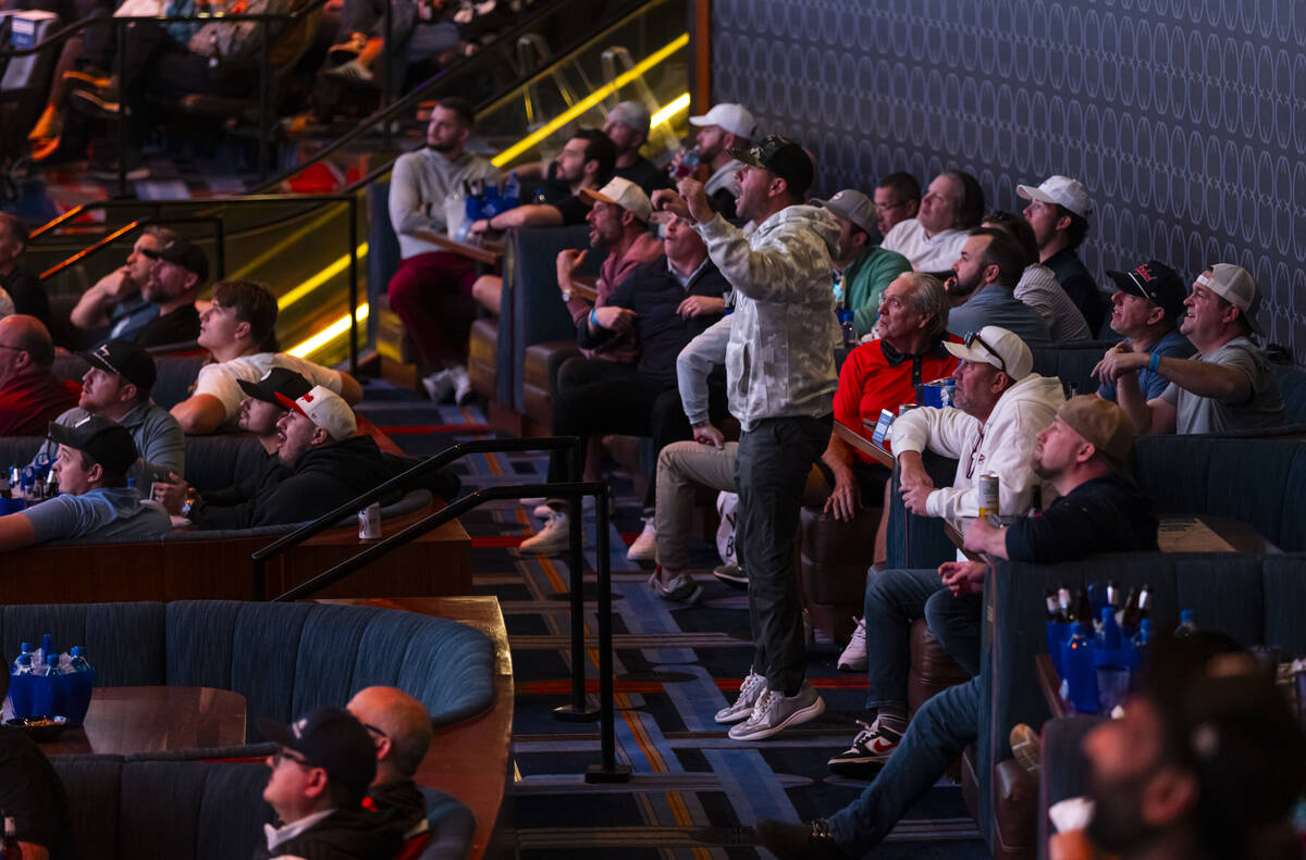 Bettors react during the AFC championship football game between the Broncos and the Patriots at ...