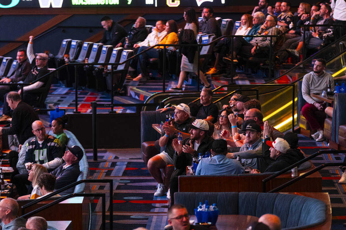 Bettors react during the AFC championship football game between the Broncos and the Patriots at ...