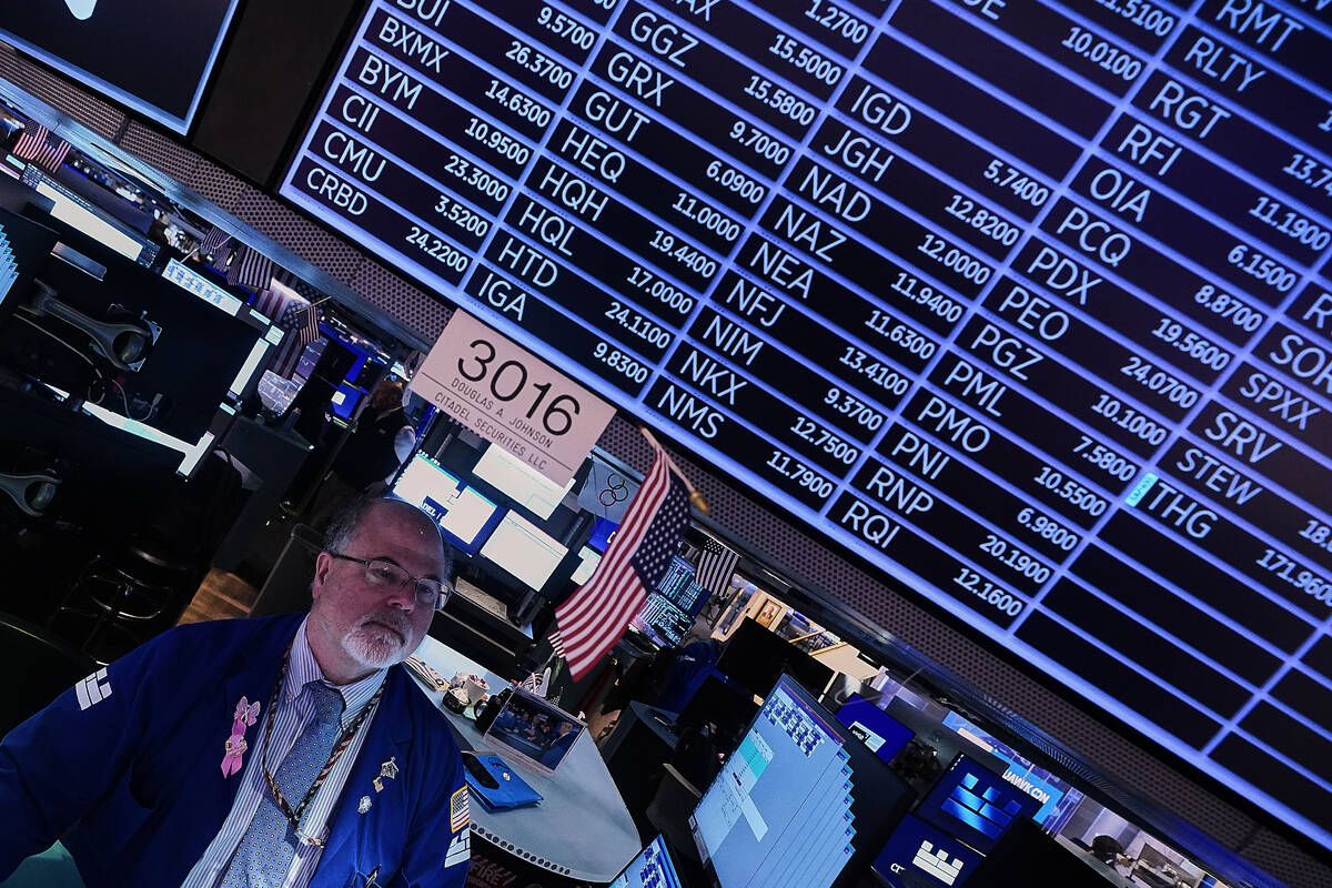 Specialist Douglas Johnson works at his post on the floor of the New York Stock Exchange, Thurs ...