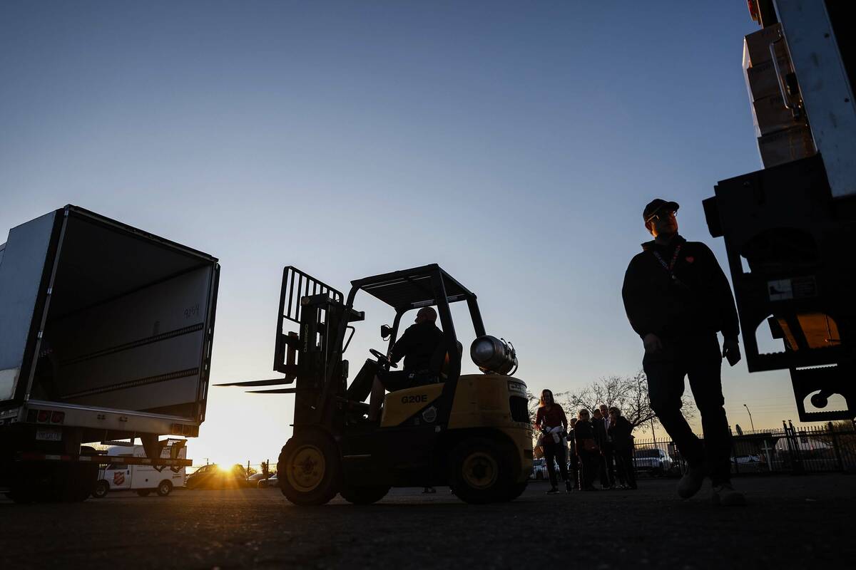 Volunteers unload a semi-truck carrying approximately 40,000 pounds of Church-donated food at t ...