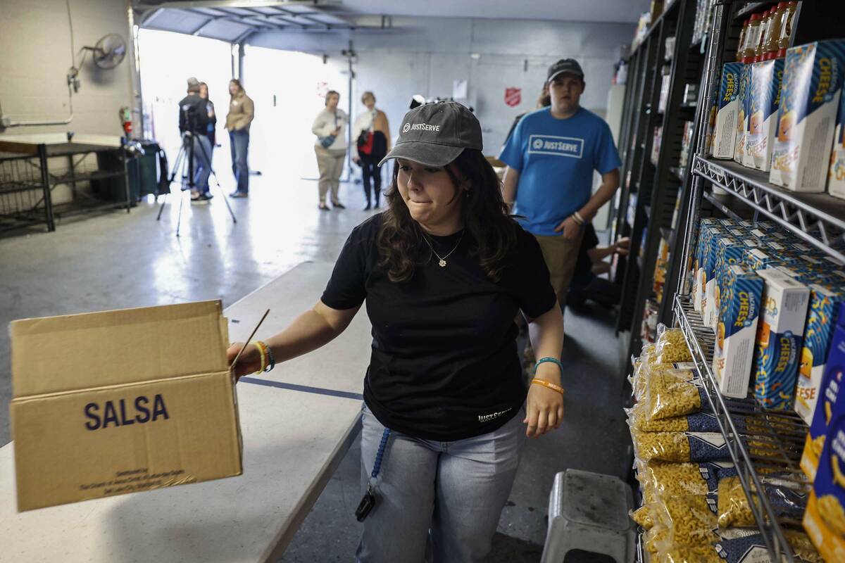 Student volunteer Emily Denman, left, stocks newly donated food at the Salvation Army Monday, J ...