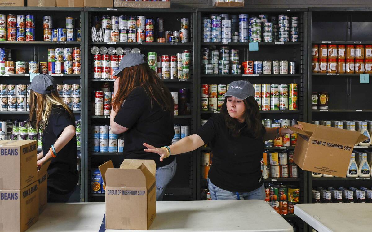 Emily Denman, right, stocks newly donated food with fellow student volunteers at the Salvation ...