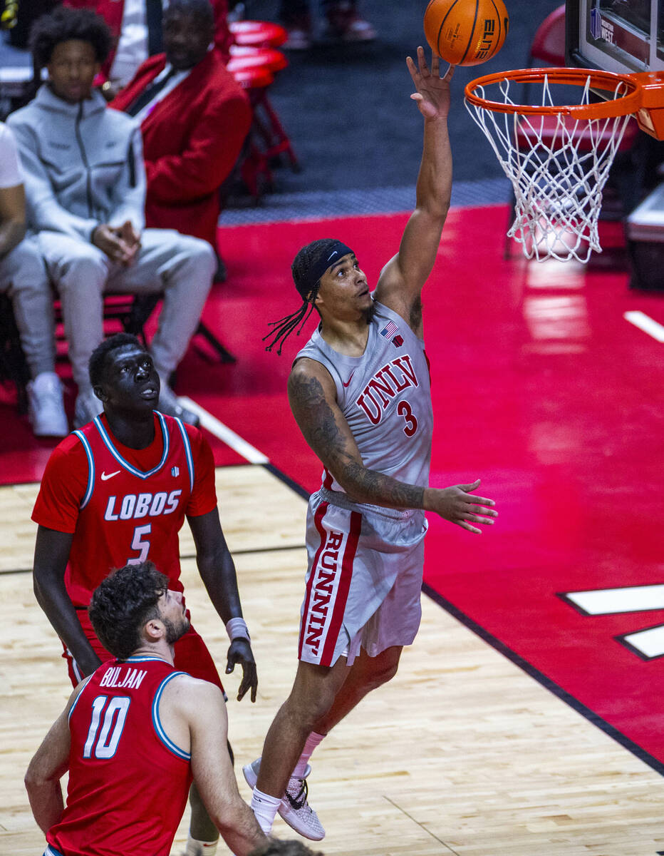 UNLV guard Howie Fleming Jr. (3) scores over New Mexico forward Antonio Chol (5) during the fir ...