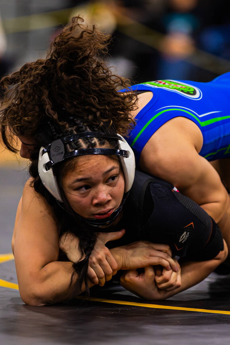 Green Valley wrestler Melanie Ortiz, top, pins down SLAM! Nevada wrestler Kaliya Klise during a ...