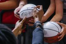 A Washington Wizards player signs a ball for a fan after a game in the 2026 NBA Summer League o ...