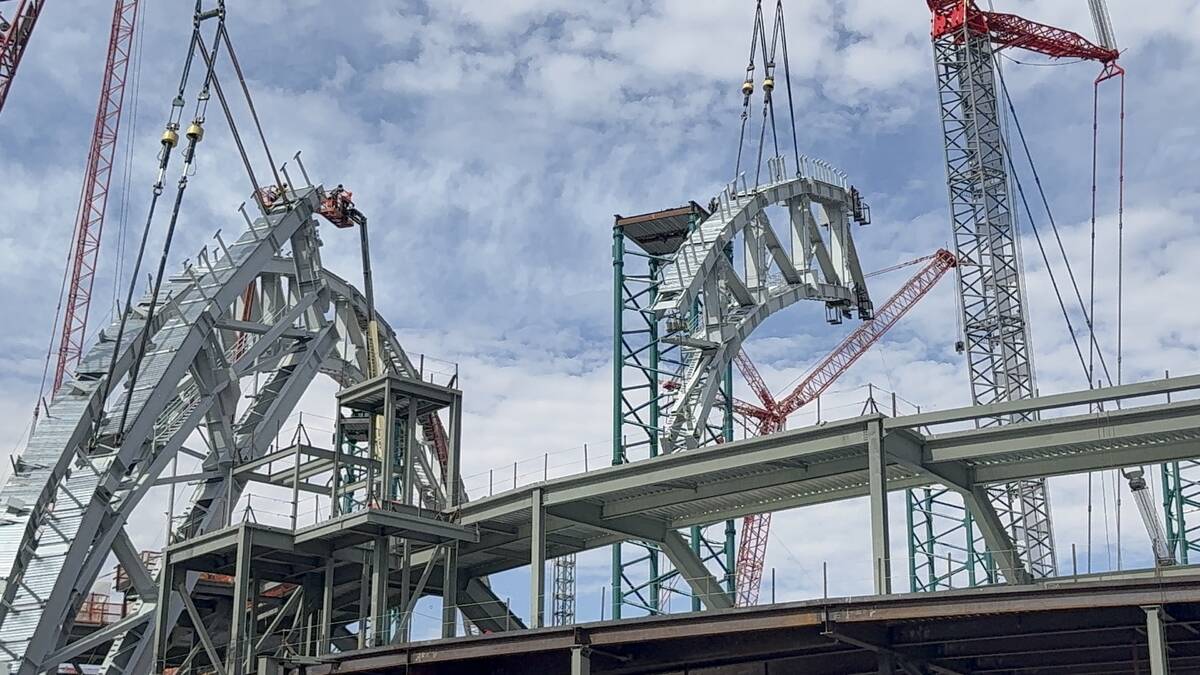 A portion of the second roof truss being lifted into place by construction workers at the Athle ...