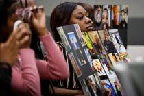 Daejia Simone holds photos showing Cameronn Carson Jr. at the sentencing hearing of Ethan Robin ...